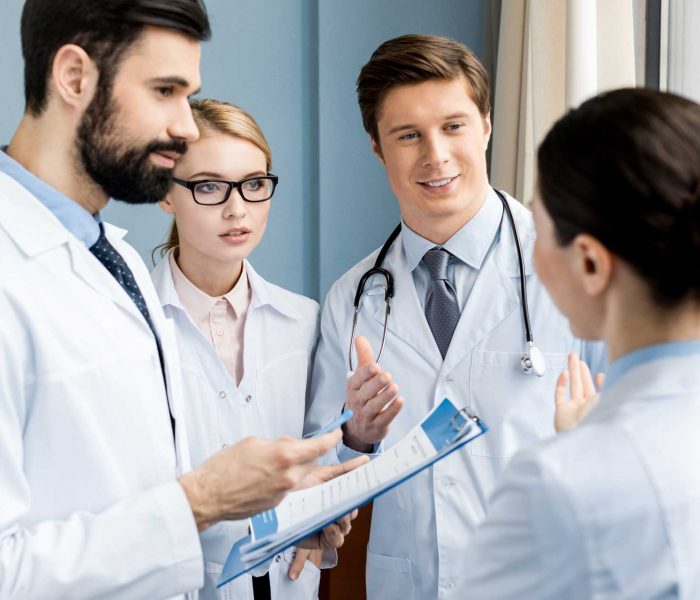 side-view-of-doctors-team-discussing-diagnosis-in-H9FJMNX.jpg